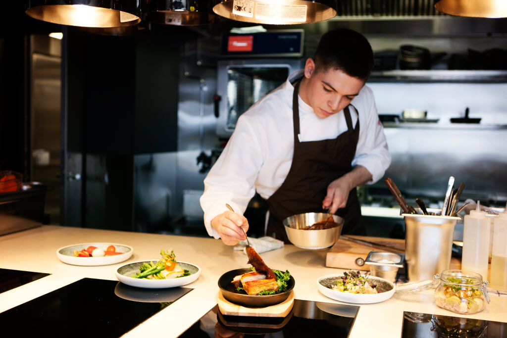 Kokk anretter mat på tallerken på Restaurant se.ua, Scandic St. Plavs plass